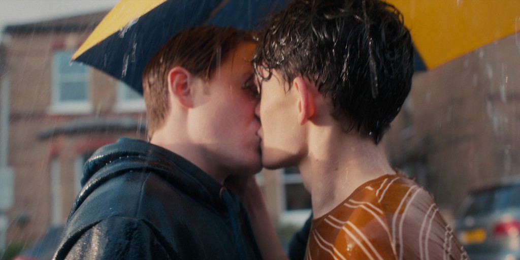 Nick et Charlie s'embrassent sous la pluie, protégés par un parapluie